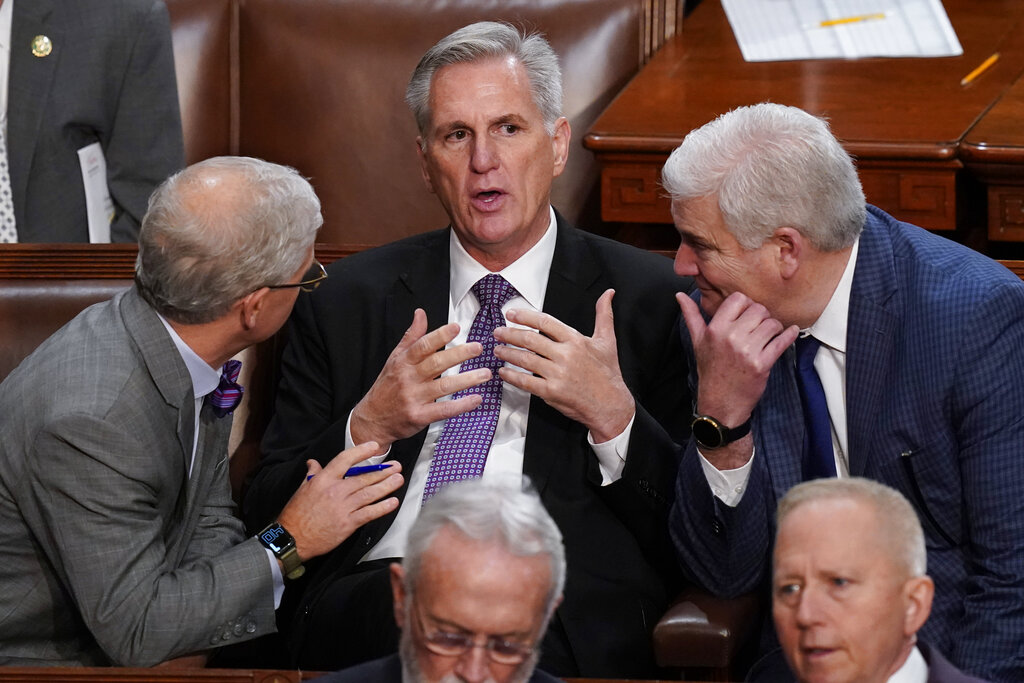 Rep. Patrick McHenry, R-N.C., left, and Rep. Tom Emmer, R-Minn., right, speaks with Rep. Kevin McCarthy, R-Calif., in the House chamber as the House meets for a second day to elect a speaker and convene the 118th Congress in Washington, Wednesday, Jan. 4, 2023.