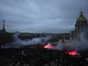 Protestors end the demonstration against plans to push back France's retirement age, at the Invalides monument, right, and the Eiffel Tower in background, Tuesday, Jan. 31, 2023 in Paris. Labor unions aimed to mobilize more than 1 million demonstrators in what one veteran left-wing leader described as a "citizens' insurrection." The nationwide strikes and protests were a crucial test both for President Emmanuel Macron's government and its opponents.