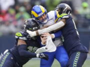 Los Angeles Rams quarterback Baker Mayfield (17) throws as Seattle Seahawks defensive tackle Quinton Jefferson (77) closes in during the second half of an NFL football game Sunday, Jan. 8, 2023, in Seattle.