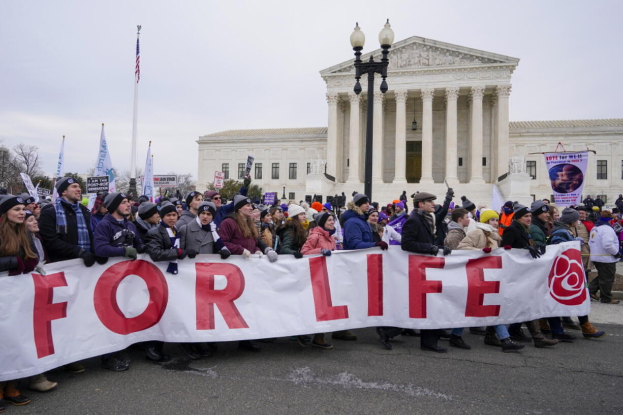 FILE - People participate in the March for Life outside the U.S. Supreme Court on Capitol Hill in Washington, Jan. 21, 2022. The annual March for Life will be held Friday, Jan. 20, 2023.