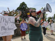 FILE - Lisa White uses a megaphone as people protest the Supreme Court ruling overturning Roe v Wade at a rally held at intersection of Union Street and County Street in New Bedford, Mass., Friday, June 24, 2022. Massachusetts has joined several other states in establishing a hotline that will offer free legal advice to women seeking abortions in the state, as well as their health care providers and helpers. Attorney General Andrea Campbell says the hotline announced Monday, Jan. 30, 2023, is in response to the U.S. Supreme Court's decision last summer that overturned Roe v. Wade and led to increasingly restrictive abortion laws in other states.