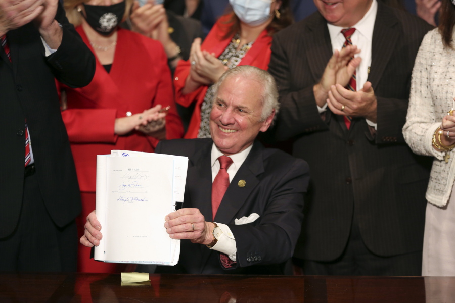 FILE - South Carolina Gov. Henry McMaster holds up a bill banning almost all abortions in the state after he signed it into law on Feb. 18, 2021, in Columbia, S.C. The South Carolina ban on abortions after cardiac activity is no more after the latest legal challenge to the state's 2021 law proved successful. The state Supreme Court ruled Thursday, Jan. 5, 2023, that the restrictions violate the state constitution's right to privacy.