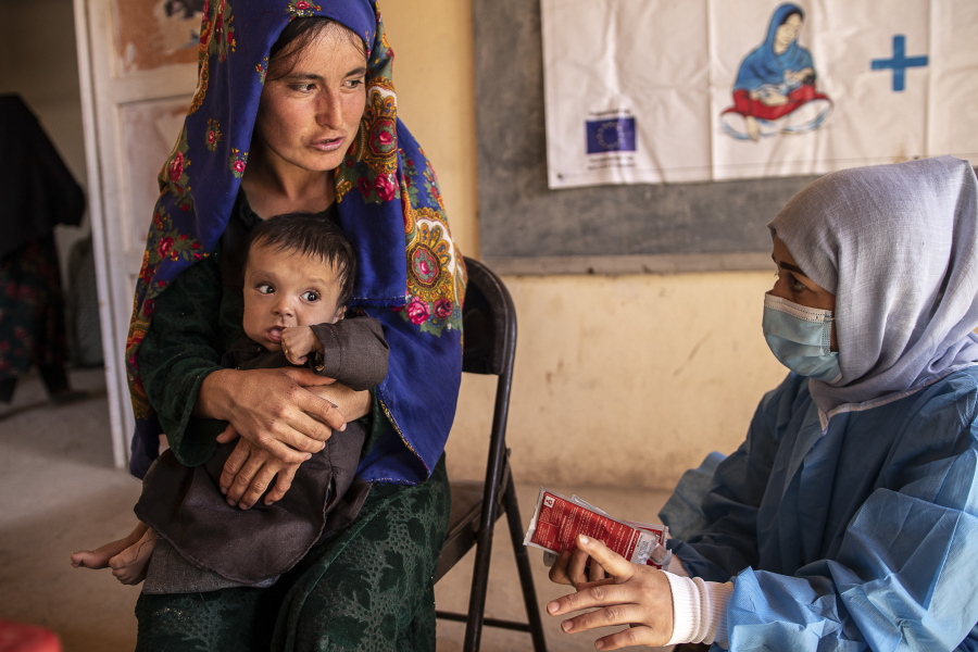 File - A Save the Children nutrition counsellor, right, explains to Nelab, 22, how to feed her 11-month-old daughter, Parsto, with therapeutic food, which is used to treat severe acute malnutrition, in Sar-e-Pul province of Afghanistan, Thursday, Sept. 29, 2022.