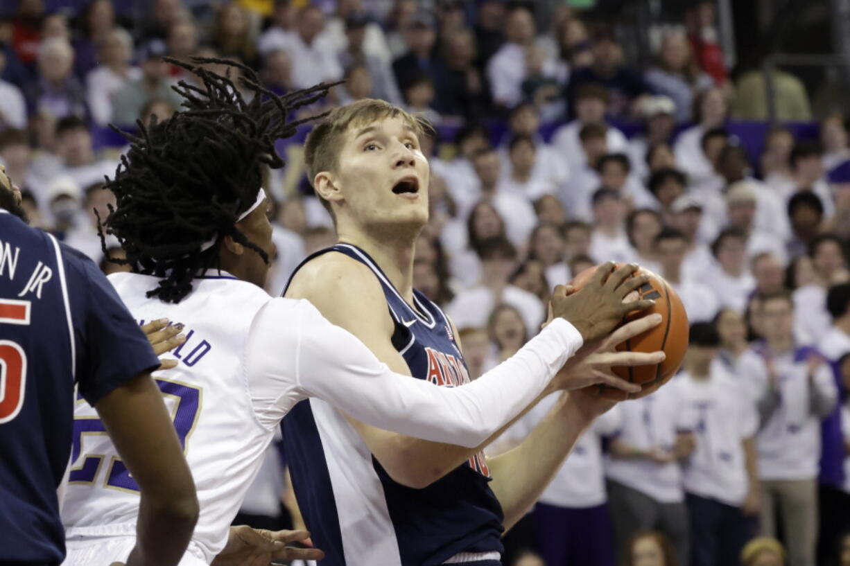 Arizona forward Azuolas Tubelis, right, looks to the basket with Washington guard Keyon Menifield defending during the first half of an NCAA college basketball game, Saturday, Jan. 28, 2023, in Seattle.