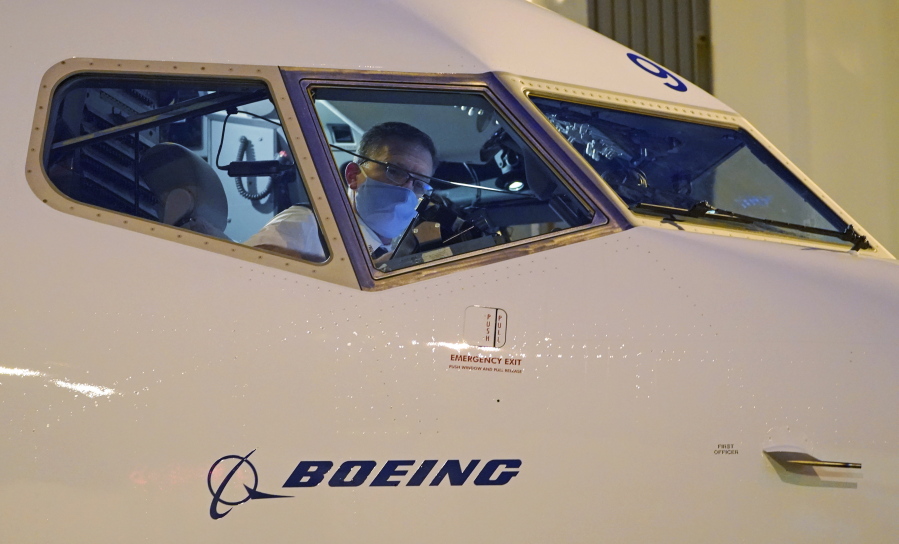FILE - Capt. Brian Eyre, who was serving as first officer, goes through pre-flight preparations in the flight deck before the first Alaska Airlines passenger flight on a Boeing 737-9 Max airplane, Monday, March 1, 2021, prior to a flight to San Diego from Seattle-Tacoma International Airport in Seattle.  Federal officials have named two dozen people to examine safety practices at Boeing, and one of them is a man whose sister died in the crash of a Boeing Max jetliner. The Federal Aviation Administration said the panel includes representatives from NASA, airlines and airline unions.  (AP Photo/Ted S.