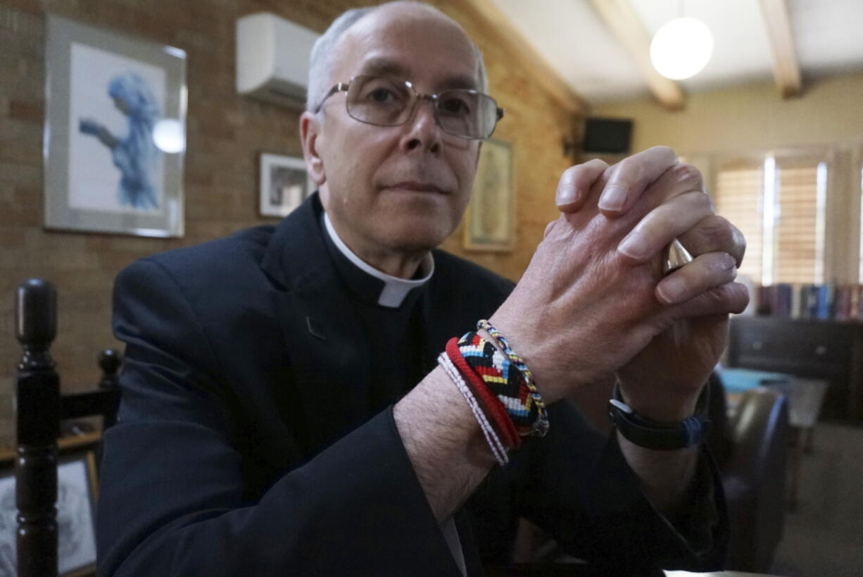 Bishop Mark Seitz of El Paso sits for a portrait in his office in El Paso, Texas, on Monday, April 4, 2022. The friendship bracelets on his wrist were braided by girls housed at a shelter on nearby Fort Bliss Army base for unaccompanied minors who crossed the U.S.-Mexican border. "Immigrants have had the experience of leaving everything that helped them to feel at home and secure in this life behind, and to depend utterly on God as they journey. ... They have so much to teach us about how God will accompany us on our journey," Seitz says.