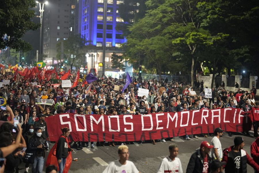 Demonstrators march holding a banner that reads in Portuguese "We are Democracy" during a protest calling for protection of the nation's democracy in Sao Paulo, Brazil, Monday, Jan. 9, 2023, a day after supporters of former President Jair Bolsonaro stormed government buildings in the capital.