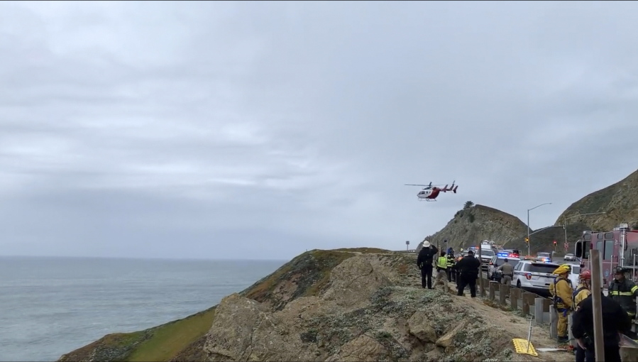 In this image from video provided by Cal Fire San Mateo, Santa Cruz Unit, emergency personnel respond to the scene after a Tesla plunged off a cliff along the Pacific Coast Highway, Monday, Jan. 2, 2023, in Northern California, near an area known as Devil's Slide, leaving four people in critical condition, a fire official said. The vehicle fell about 250 feet (76.20 meters) from the highway, the fire official said. Motorists were told to expect delays as rescuers worked. Helicopters were expected to transport four people to hospitals.