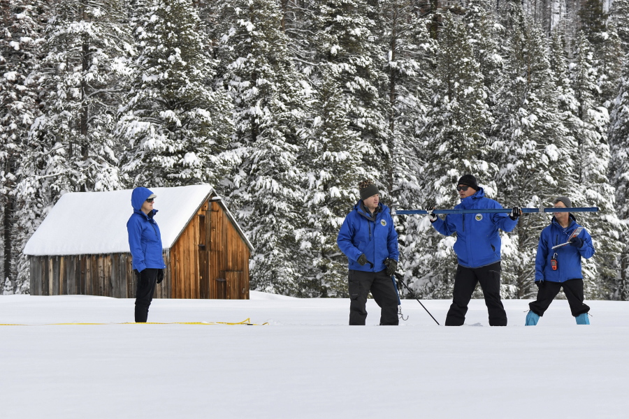 In this photo provided by the California Department of Water Resources, forecasting chief Sean de Guzman, second from right, and engineers work the measurement phase of the first media snow survey of the season at Phillips Station in the Sierra Nevada Mountains, Calif., Tuesday, Jan. 3, 2023. The snowpack in California's mountains is off to one of its best starts in 40 years, officials announced Tuesday, offering hope that the drought-stricken state could soon see relief in the spring when the snow melts and flows into reservoirs that provide water for drinking and farming.