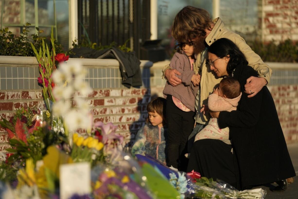 FILE - A family gathers at a memorial outside the Star Ballroom Dance Studio, the site of a mass shooting, on Tuesday, Jan. 24, 2023, in Monterey Park, Calif. In the course of 48 hours, two gunmen went on shooting rampages at both ends of California that left 18 dead and 10 wounded.