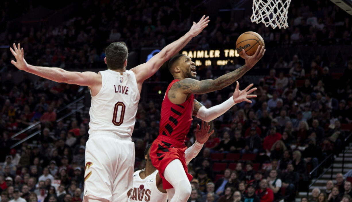 Portland Trail Blazers guard Damian Lillard, right, shoots next to Cleveland Cavaliers forward Kevin Love during the second half of an NBA basketball game in Portland, Ore., Thursday, Jan. 12, 2023.