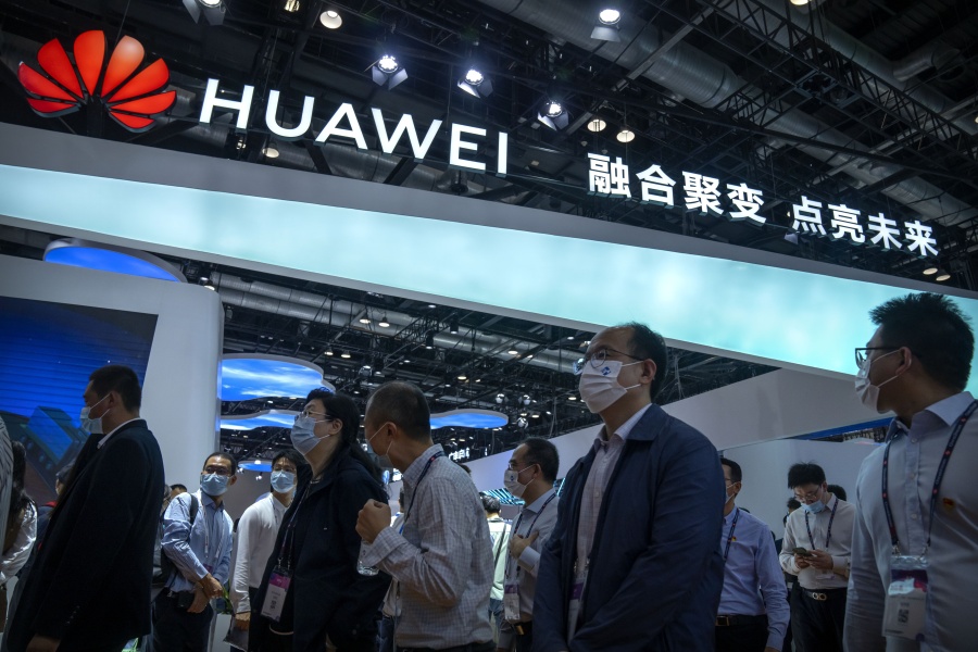 FILE - Visitors walk past a booth for Chinese technology firm Huawei at the PT Expo in Beijing on Sept. 28, 2021. China's government accused Washington on Tuesday, Jan. 31, 2023, of pursuing "technology hegemony" following news reports the United States might step up pressure on tech giant Huawei by blocking all access to American suppliers.