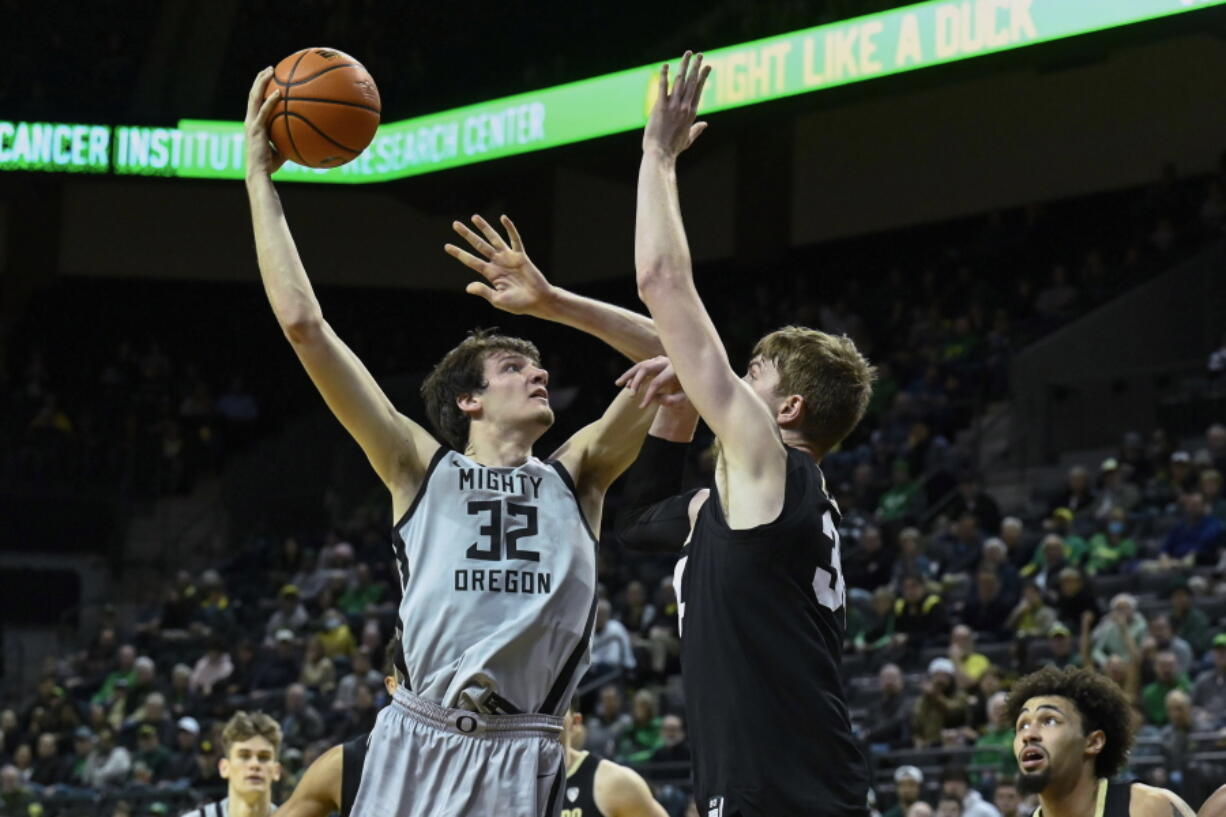 Oregon center Nate Bittle (32) shoots over Colorado center Lawson Lovering, center right, during the first half of an NCAA college basketball game Thursday, Jan. 26, 2023, in Eugene, Ore.