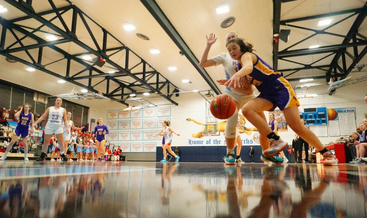 Columbia River forward Emma Iniguez tries to escape the defense of Mark Morris junior Charlie Blain in early game action at Mark Morris High School in Longview on Friday night. The Rapids won the 2A GSHLgirls basketball game by the score of 50-45.