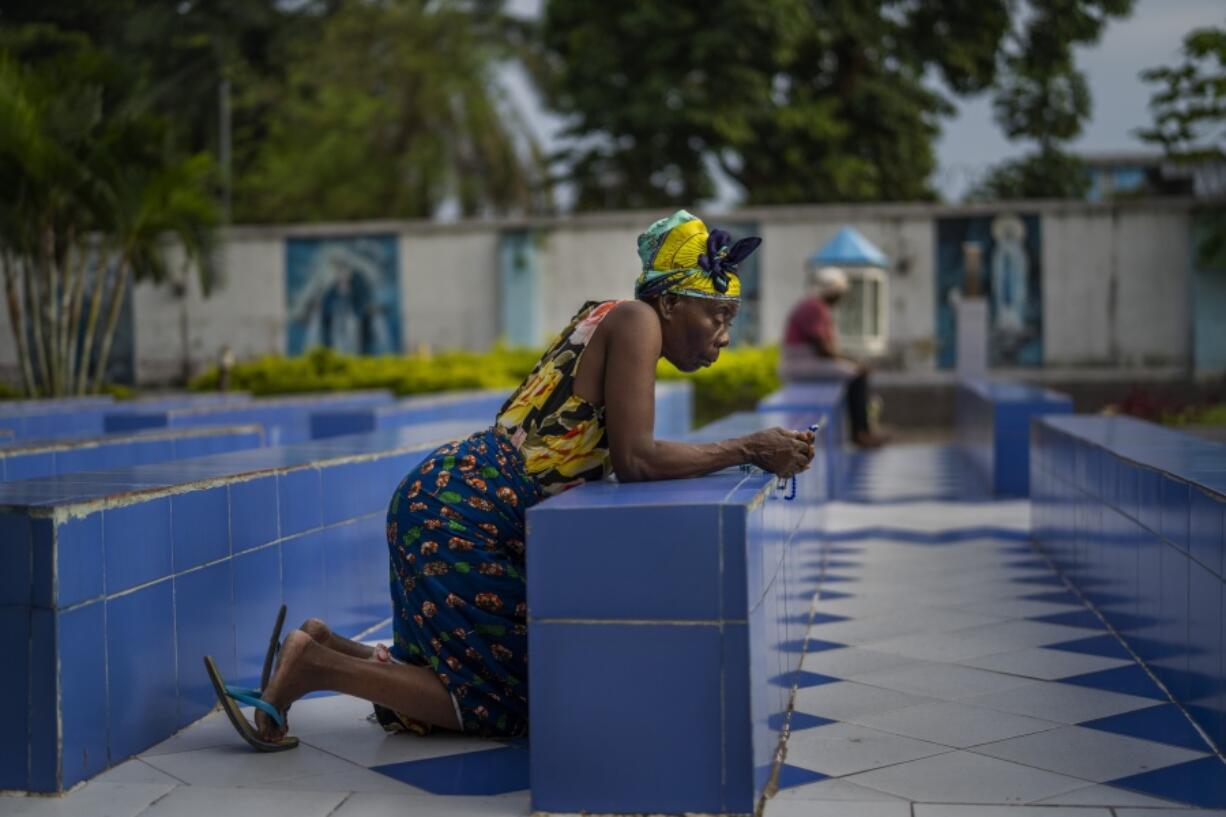 A woman prays outside the Cathedral Notre Dame du Congo in Kinshasa, Democratic Republic of the Congo Saturday Jan. 28, 2023. Pope Francis will be in Congo and South Sudan for a six-day trip starting Jan, 31, hoping to bring comfort and encouragement to two countries that have been riven by poverty, conflicts and what he calls a "colonialist mentality" that has exploited Africa for centuries.