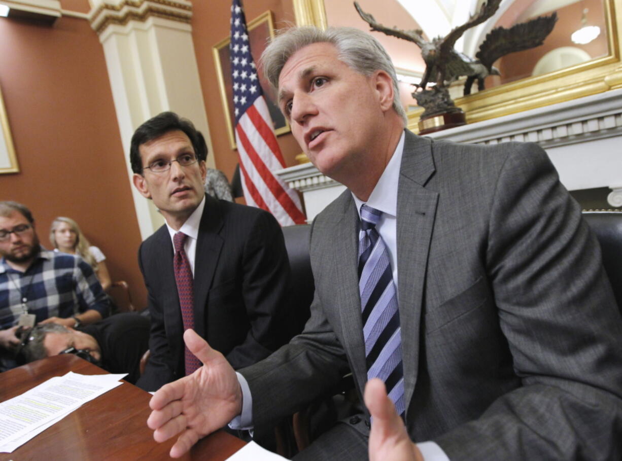 FILE - Then-House Majority Whip Kevin McCarthy of Calif., right, joined by House Majority Leader Eric Cantor of Va., speaks to reporters about President Obama's debt reduction plan and other issues, on Capitol Hill in Washington, on Sept. 20, 2013. Lessons learned from the debt ceiling standoff more than a decade ago are rippling through Washington. Back in 2011 the debate around raising the debt ceiling was eerily familiar. Newly elected House Republicans were eager to confront the Democratic president and force spending cuts. (AP Photo/J.