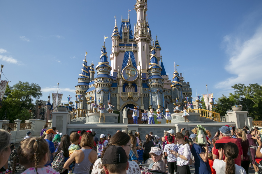 FILE - Performers dressed as Mickey Mouse, Minnie Mouse, Goofy, Donald Duck and Daisy Duck entertain visitors at Cinderella Castle at Walt Disney World Resort in Lake Buena Vista, Florida, on April 18, 2022. Florida lawmakers will move to increase state control of Walt Disney World's private government, according to a notice published Friday, Jan.
