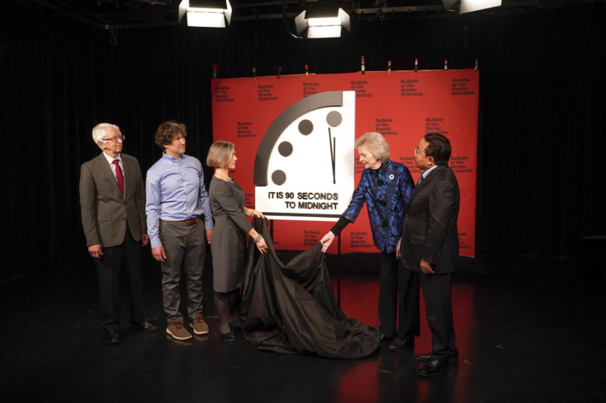 Siegfried Hecker, from left, Daniel Holz, Sharon Squassoni, Mary Robinson and Elbegdorj Tsakhia with the Bulletin of the Atomic Scientists, remove a cloth covering the Doomsday Clock before a virtual news conference at the National Press Club in Washington, Tuesday, Jan. 24, 2023. The Bulletin of the Atomic Scientists announced that it has moved the minute hand of the Doomsday Clock to 90 seconds to midnight.