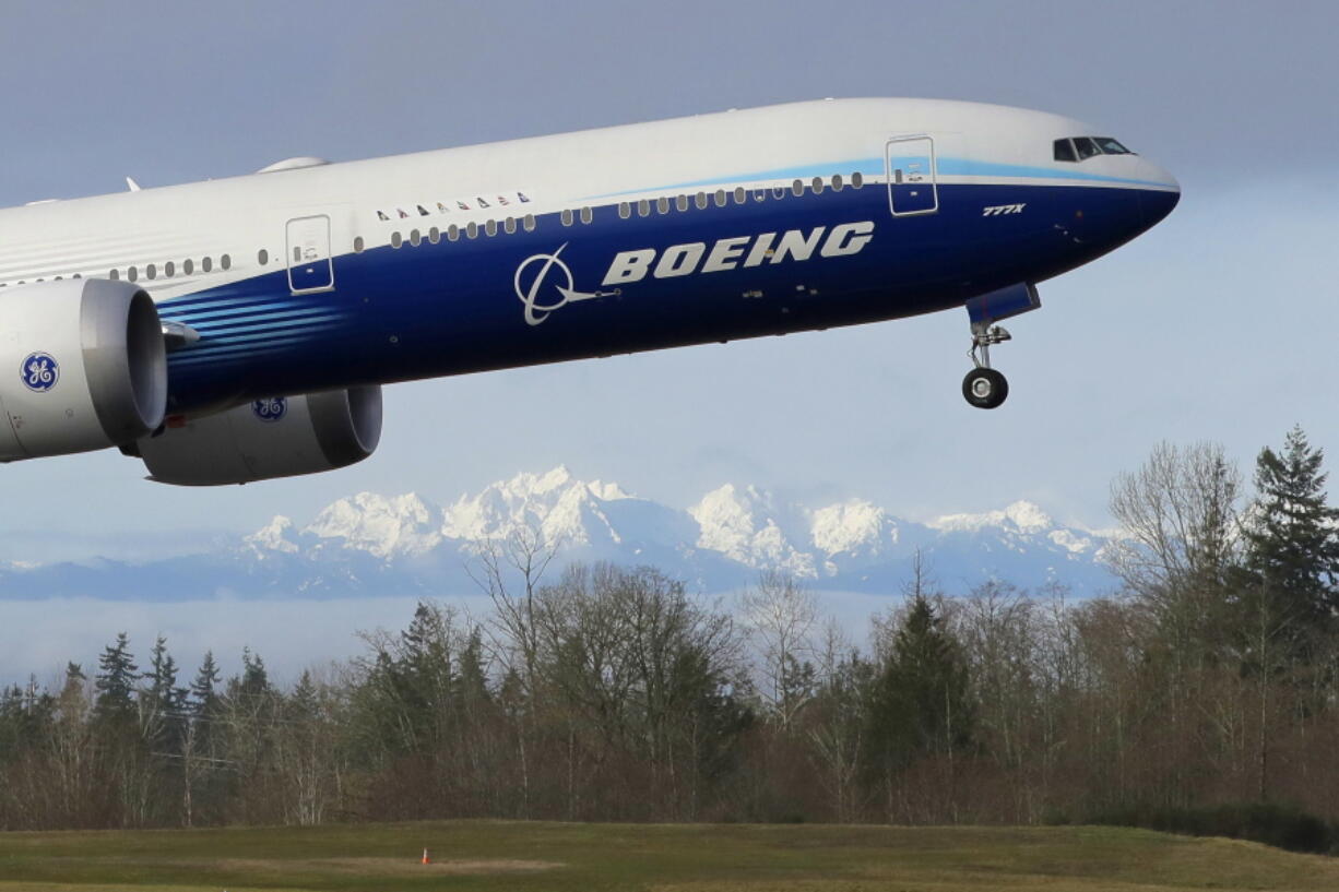 FILE - In this Jan. 25, 2020, file photo a Boeing 777X airplane takes off on its first flight with the Olympic Mountains in the background at Paine Field in Everett, Wash. Boeing Co. reports earnings on Wednesday, Jan. 25, 2023.  (AP Photo/Ted S.