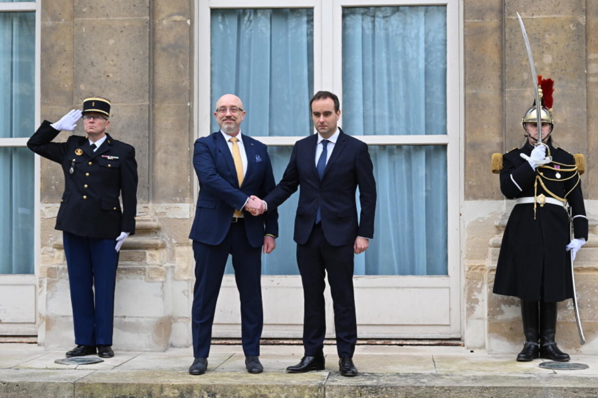 French Defense Minister Sebastien Lecornu, center right, and Ukrainian Minister of Defense Oleksii Reznikov pose during Reznikov's official visit at the French Defense Ministry, in Paris Tuesday, Jan. 31, 2023. Ukraine's defense minister pays his first official visit to France, meeting with Macron and the defense minister, as Ukraine sets its sights on Western warplanes and other heavy weaponry to push back Russian forces.
