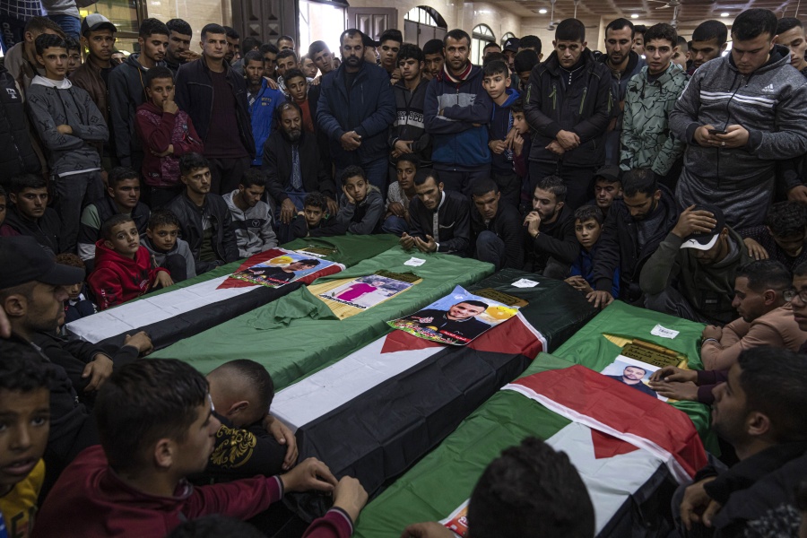 FILE, Mourners gather around the coffins of four out of eight Palestinian migrants who died off the Tunisian coast, during their funeral at a mosque in Rafah in the southern Gaza Strip, Sunday, Dec. 18, 2022. As a rising number of Gazans are drowning in the sea en route to a better life in Europe, Gaza's Hamas rulers are moving to comfortable life in upscale Middle East hotels, prompted a rare outpouring of anger at home, where the economy collapses and 2.3 million people remain effectively trapped in the tiny, conflict-scarred territory.