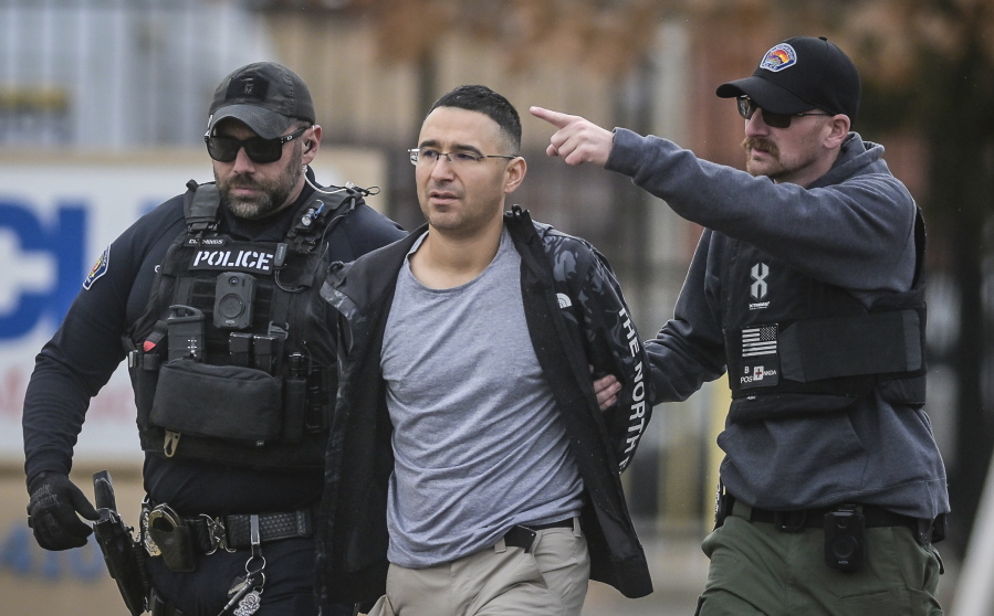 Solomon Pena, center, a Republican candidate for New Mexico House District 14, is taken into custody by Albuquerque Police officers, Monday, Jan. 16, 2023, in southwest Albuquerque, N.M. Pena was arrested in connection with a recent series of drive-by shootings targeting Democratic lawmakers in New Mexico. (Roberto E.