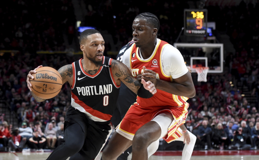 Portland Trail Blazers guard Damian Lillard, left, drives to the basket on Atlanta Hawks center Clint Capela, right, during the second half of an NBA basketball game in Portland, Ore., Monday, Jan. 30, 2023. The Blazers won 129-125.