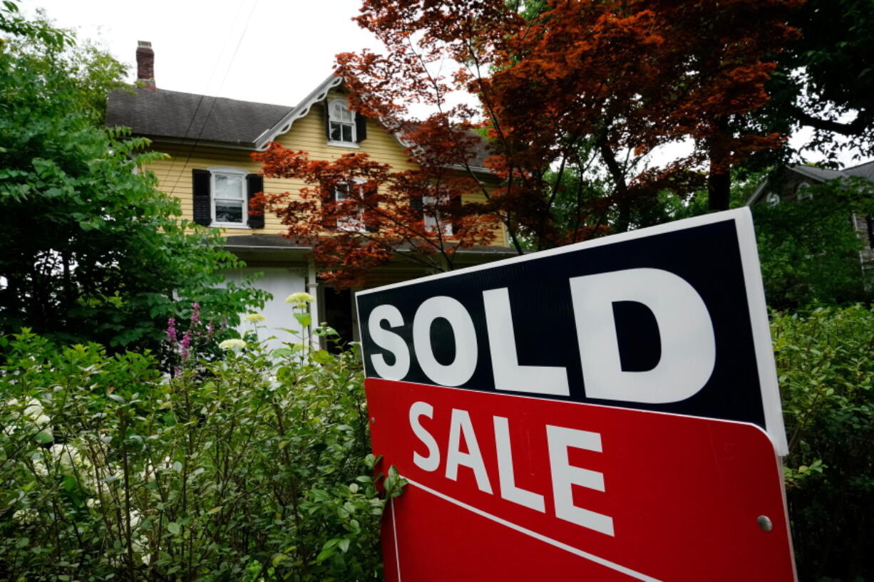 FILE - A sale sign stands outside a home in Wyndmoor, Pa., Wednesday, June 22, 2022. On Friday, the National Association of Realtors reports on sales of existing homes in December.