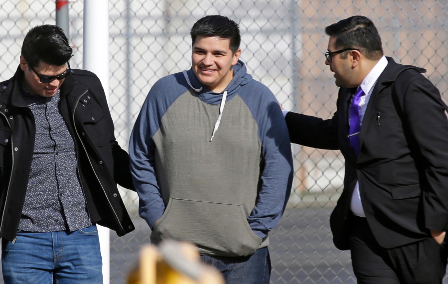 FILE - In this March 29, 2017 file photo, Daniel Ramirez Medina, center, who is a participant in the Deferred Action for Childhood Arrivals Program, walks out of the Northwest Detention Center in Tacoma, Wash., with his attorney, Luis Cortes, right, and his brother, left, who has not been identified by name, after Ramirez was released from federal custody. Ramirez who was arrested by U.S. immigration agents in 2017 despite his participation in a program designed to protect those brought to the U.S. illegally as children will be allowed to remain in the country for at least the next four years under a settlement with the Justice Department. (AP Photo/Ted S.