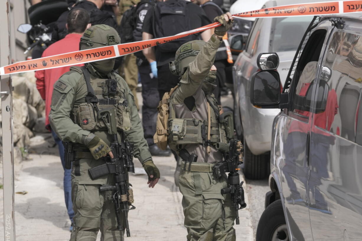 Israeli policemen secure a shooting attack site in east Jerusalem, Saturday, Jan. 28, 2023. A Palestinian gunman opened fire in east Jerusalem on Saturday, wounding at least two people less than a day after another attacker killed seven outside a synagogue there in the deadliest attack in the city since 2008.