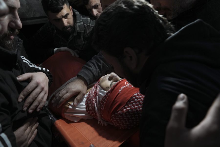 Mourners gather around the body of 14-year-old Palestinian Omar Khumour during his funeral in the West Bank city of Bethlehem, Monday, Jan. 16, 2023. The Palestinian Health Ministry said Khumour died after being struck in the head by a bullet during an Israeli military raid into Dheisha refugee camp near the city of Bethlehem. The Israeli army said that forces entered the Dheisha camp and were bombarded by Molotov cocktails and rocks. It said soldiers responded to the onslaught with live fire.