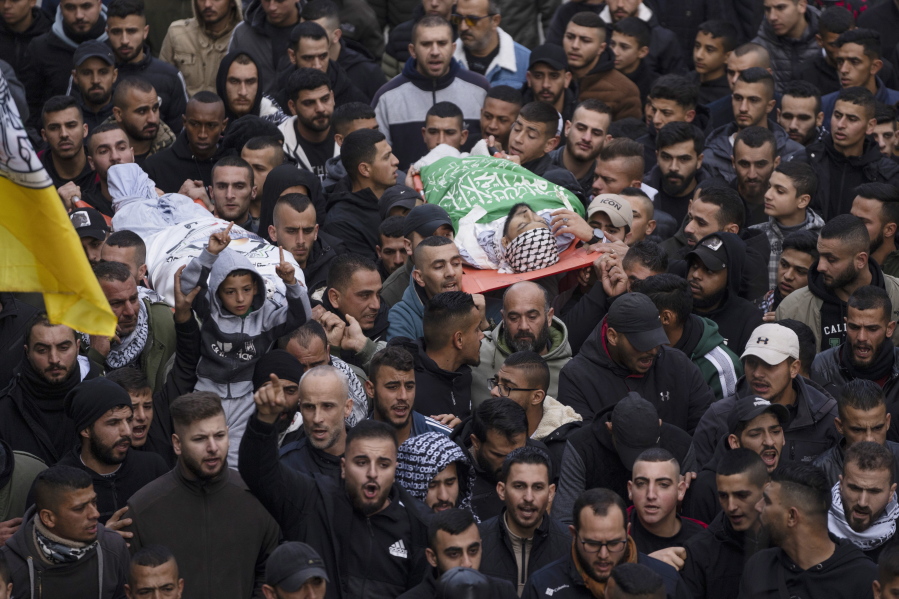 Mourners carry the bodies of Samer Houshiyeh, 21, left, and Fouad Abed, 25, during their funeral in the West Bank city of Jenin, Monday, Jan. 2, 2023. The two men were killed in the village of Kafr Dan near the northern city of Jenin. The Israeli military said it entered Kafr Dan late Sunday to demolish the houses of two Palestinian gunmen who killed an Israeli soldier during a firefight in September. The military said troops came under heavy fire and fired back at the shooters.