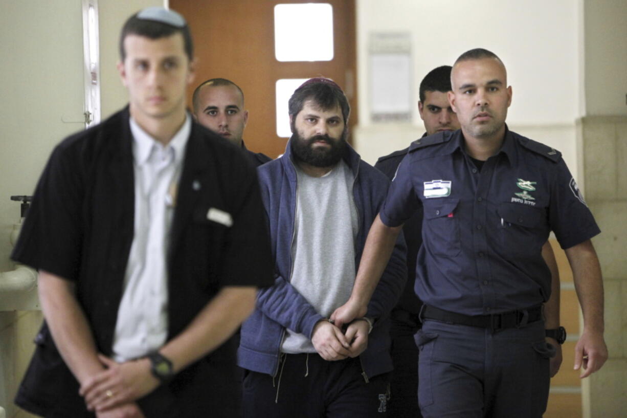 FILE - Yosef Haim Ben David, center, arrives at Jerusalem court during his murder trial in the death of a 16-year-old Palestinian boy, in Jerusalem, Tuesday, March 22, 2016. An Israeli group raising funds for Jewish radicals convicted in some of the country's most notorious hate crimes, Including Ben David, is collecting tax-exempt donations from Americans, according to an investigation by the AP and non-profit Israeli investigative platform. That is a sign that Israel's FAR right is gaining a new foothold in the United States.