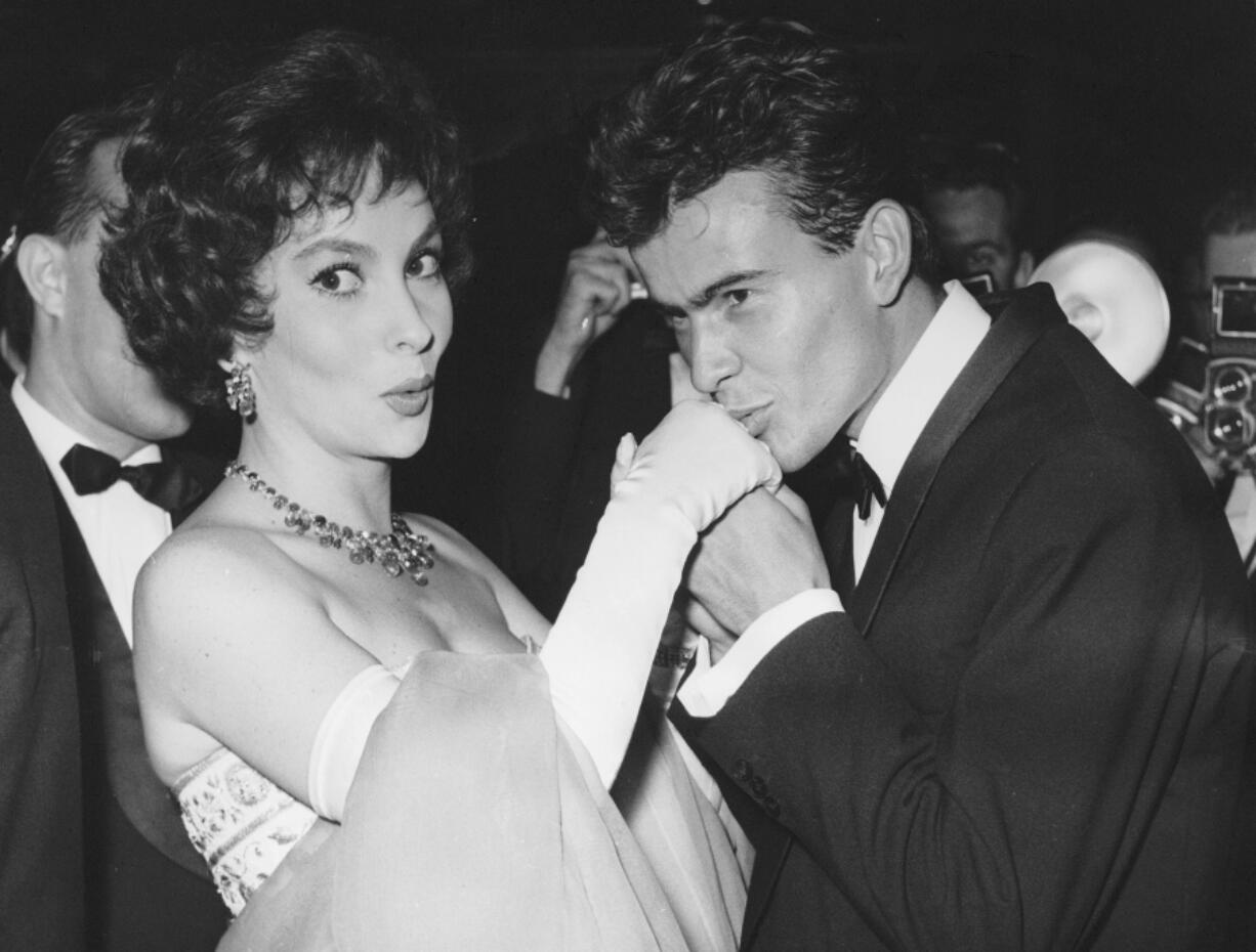 FILE - German actor Horst Buchholz kisses the hand of Italian actress Gina Lollobrigida, during the International Film Festival (Berlinale) in Berlin, Germany, July 5, 1958. (AP Photo/Werner Kreusch, File) Lollobrigida has died in Rome at age 95. Italian news agency Lapresse reported Lollobrigida's death on Monday, Jan. 16, 2023 quoting Tuscany Gov. Eugenio Giani.