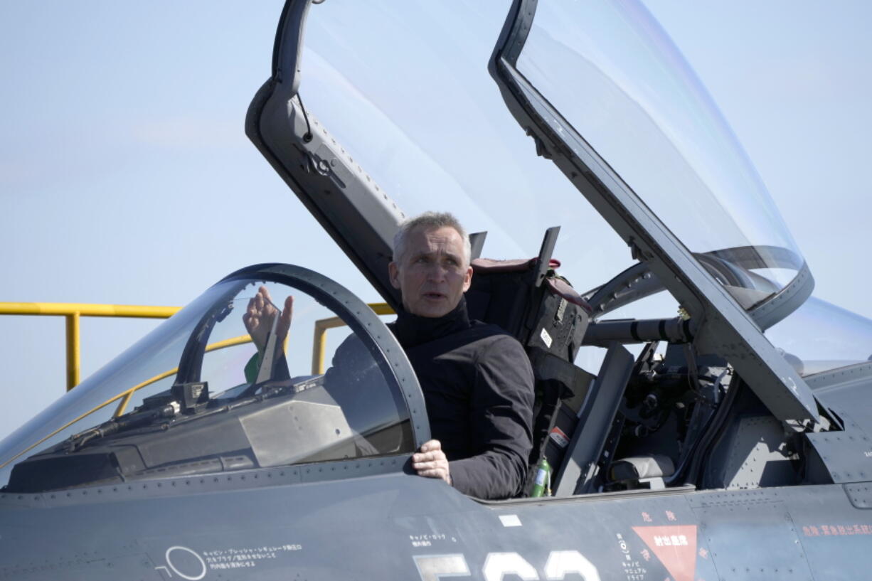 NATO Secretary-General Jens Stoltenberg sits on the cockpit of Japan's F-2 fighter jet of Japan's Air Self-Defense Force at Iruma Air Base in Sayama, northwest of Tokyo, Tuesday, Jan. 31, 2023.