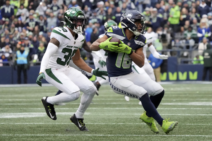 Seattle Seahawks wide receiver Tyler Lockett (16) runs after the catch as New York Jets cornerback Michael Carter II (30) defends during the first half of an NFL football game, Sunday, Jan. 1, 2023, in Seattle. (AP Photo/Ted S.