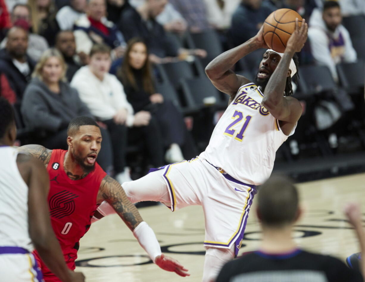 Los Angeles Lakers guard Patrick Beverley, right, shoots while being fouled by Portland Trail Blazers guard Damian Lillard during the second half of an NBA basketball game in Portland, Ore., Sunday, Jan. 22, 2023.
