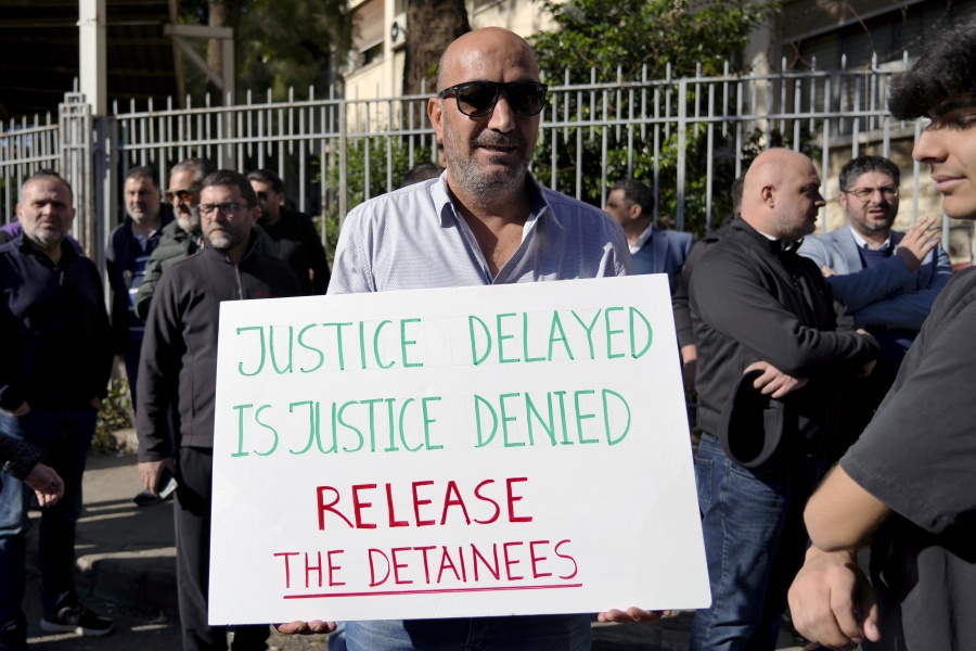 A relative of detainees in the Aug. 4, 2020 Beirut port blast investigation holds a placard during a protest in front of the Justice Palace in Beirut, Lebanon, Jan. 19, 2023. The judge Tarek Bitar investigating Beirut's massive 2020 port blast resumed work Monday, Jan. 23, 2023 after a nearly 13-month halt, ordering the release of some detainees and announcing plans to charge others, including two top generals, judicial officials said.