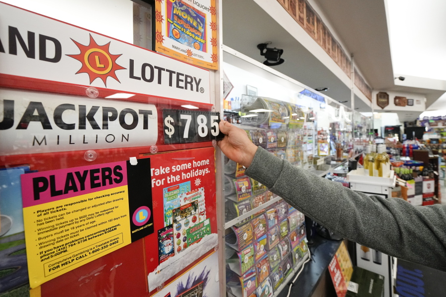 A clerk at Broad Street Liquors updates the Mega Millions jackpot at the store's lottery counter, Tuesday, Jan. 3, 2023, in Timonium, Md.