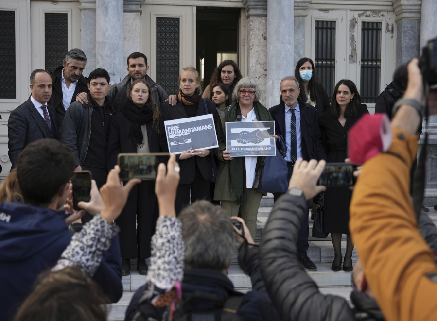 Protesters, laywyers and aid workers pose for the media outside a court in Mytilene, on the northeastern Aegean island of Lesbos, Greece, Friday, Jan. 13, 2023. The trial of 24 Greek and foreign aid workers and volunteers who participated in migrant rescue operations has drawn widespread criticism from international human rights groups.