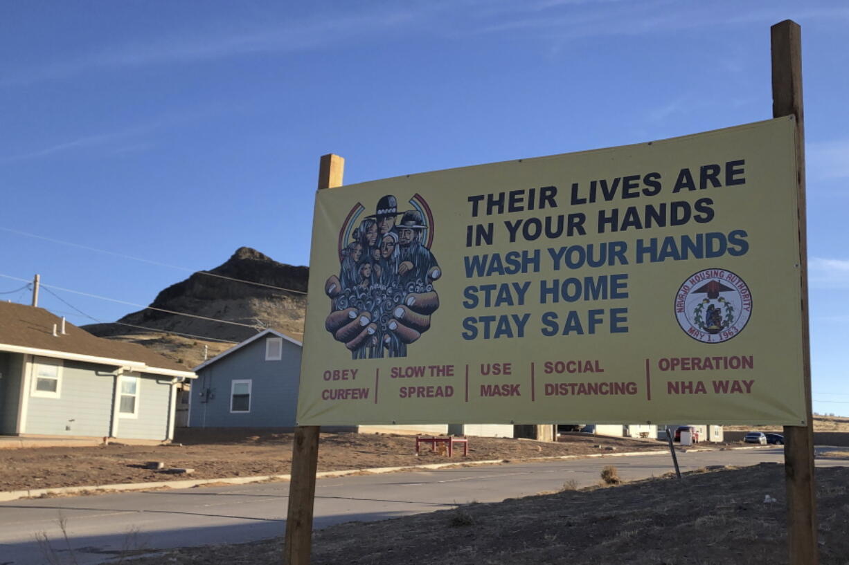 FILE - A sign urging safety measures during the coronavirus pandemic is displayed in Teesto, Ariz., on the Navajo Nation on Feb. 11, 2021. The Navajo Nation has rescinded a mask mandate that has been in effect since the early days of the coronavirus pandemic, officials announced Friday, Jan. 20, 2023, fulfilling a pledge that new tribal President Buu Nygren made while campaigning for the office.