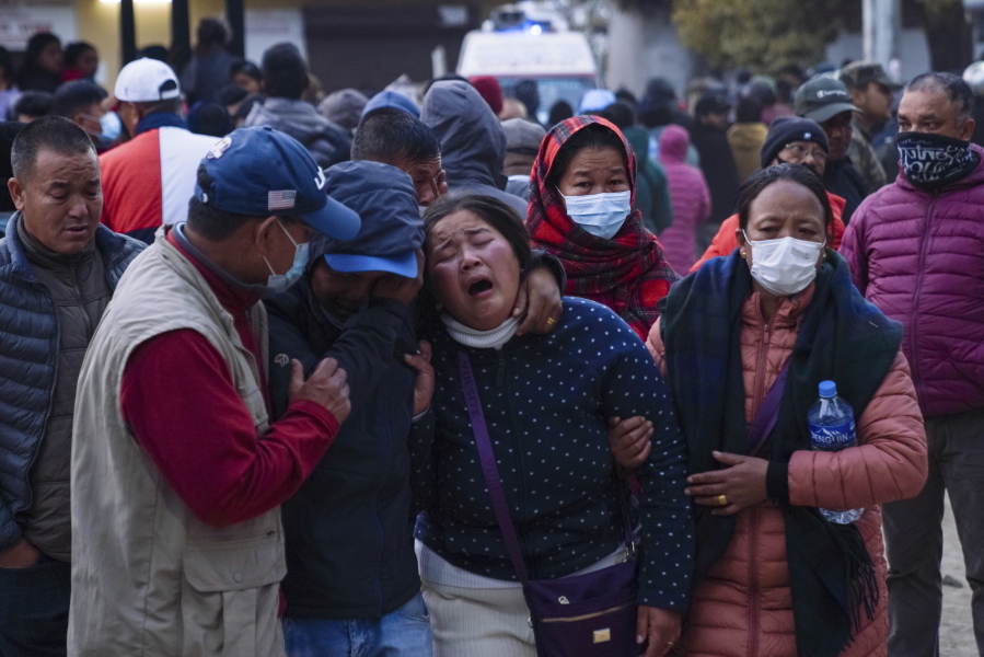 A woman cries as the body of a relative, victim of a plane crash, is brought to a hospital in Pokhara, Nepal, Sunday, Jan. 15, 2023. A plane making a 27-minute flight to a Nepal tourist town crashed into a gorge Sunday while attempting to land at a newly opened airport, killing at least 68 of the 72 people aboard. At least one witness reported hearing cries for help from within the fiery wreck, the country's deadliest airplane accident in three decades.