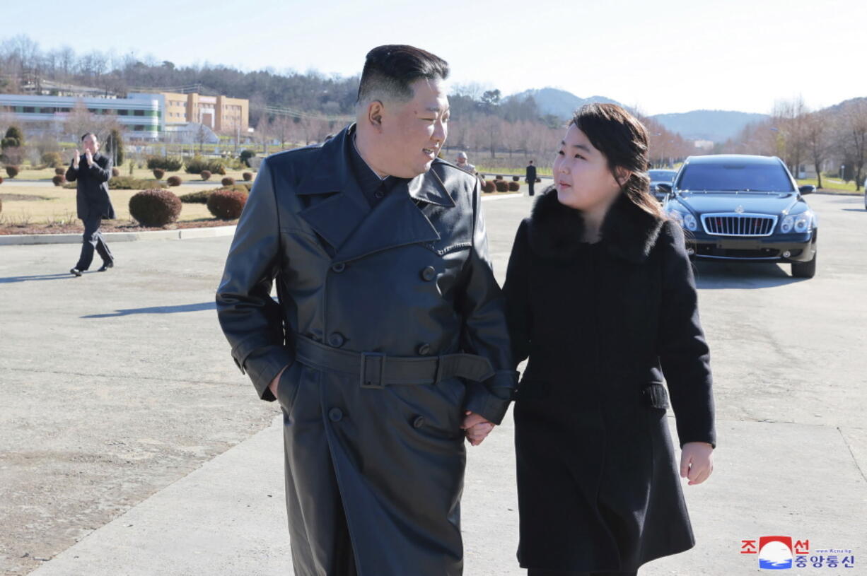 This undated photo provided on Nov. 27, 2022, by the North Korean government shows North Korean leader Kim Jong Un, left, and his daughter, right, walk to a photo session with those involved in the recent launch of what it says a Hwasong-17 intercontinental ballistic missile, at an unidentified location in North Korea. Independent journalists were not given access to cover the event depicted in this image distributed by the North Korean government. The content of this image is as provided and cannot be independently verified. Korean language watermark on image as provided by source reads: "KCNA" which is the abbreviation for Korean Central News Agency.