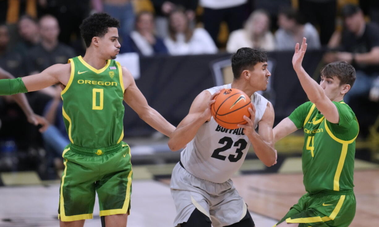 Colorado forward Tristan da Silva, center, looks to pass the ball as Oregon guards Will Richardson, left, and Brennan Rigsby defend during the first half of an NCAA college basketball game Thursday, Jan. 5, 2023, in Boulder, Colo.