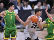 Colorado forward Tristan da Silva, center, looks to pass the ball as Oregon guards Will Richardson, left, and Brennan Rigsby defend during the first half of an NCAA college basketball game Thursday, Jan. 5, 2023, in Boulder, Colo.