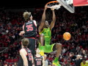 Oregon center N'Faly Dante (1) dunks against Utah center Branden Carlson (35) during the first half of an NCAA college basketball game Saturday, Jan. 7, 2023, in Salt Lake City.