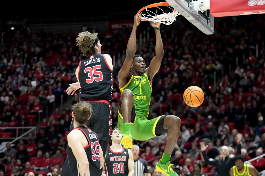 Oregon center N'Faly Dante (1) dunks against Utah center Branden Carlson (35) during the first half of an NCAA college basketball game Saturday, Jan. 7, 2023, in Salt Lake City.