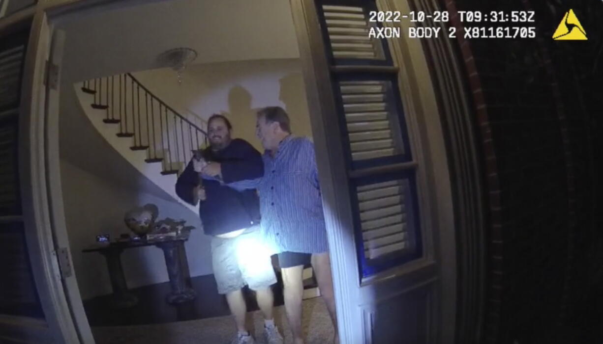 In this image taken from San Francisco Police Department body-camera video, the husband of former U.S. House Speaker Nancy Pelosi, Paul Pelosi, right, fights for control of a hammer with his assailant during a brutal attack in the couple's San Francisco home on Oct. 28, 2022. The body-camera footage shows the suspect David DePape wrest the tool from the 82-year-old Pelosi and lunge toward him the hammer over his head. The blow to Pelosi occurs out of view and the officers -- one of them cursing -- rush into the house and jump on DePape.