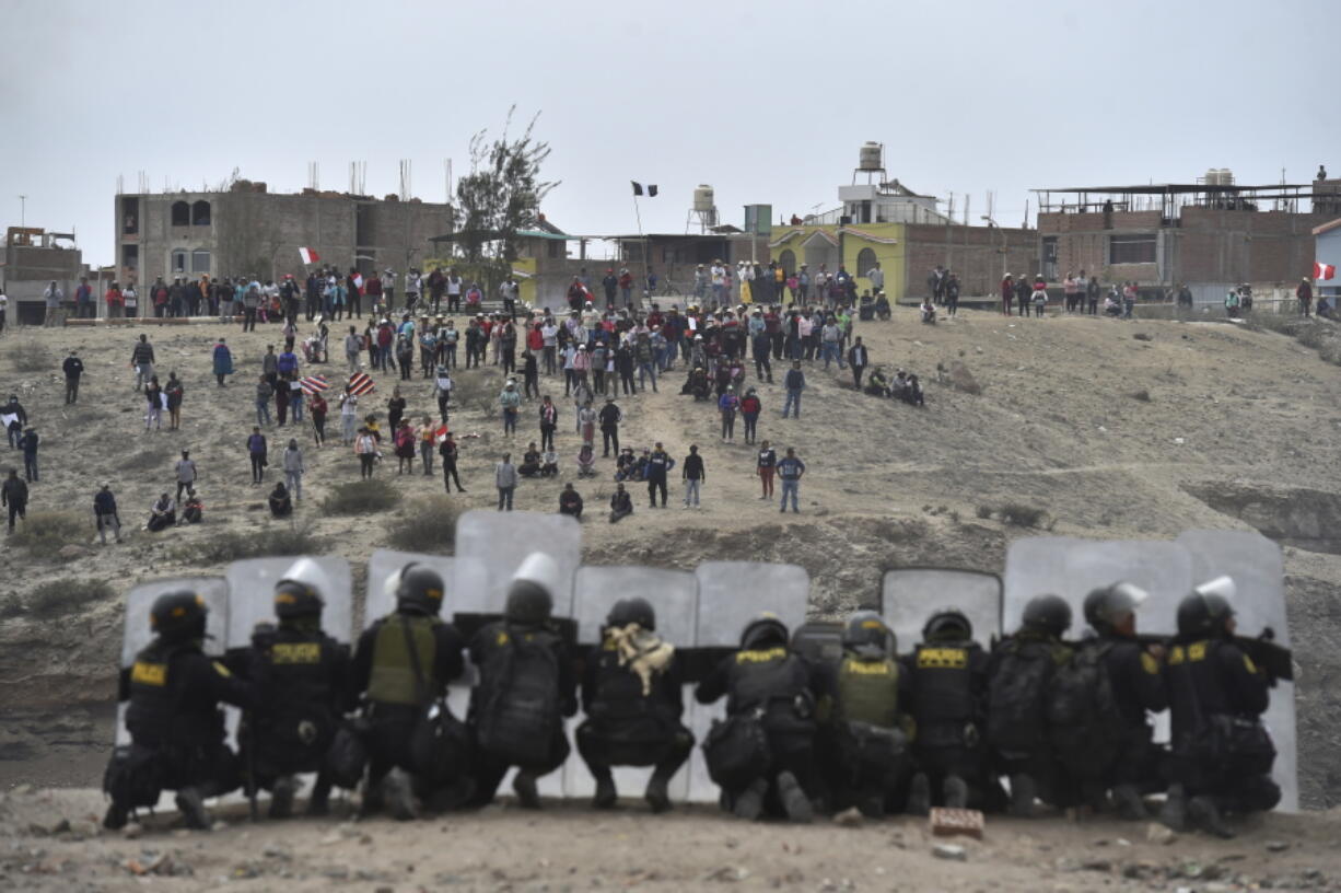 Anti-government protesters face off with security outside Alfredo Rodriguez Ballon airport in Arequipa, Peru, Thursday, Jan. 19, 2023. Protesters are seeking immediate elections, President Dina Boluarte's resignation, the release of ousted President Pedro Castillo and justice for up to 48 protesters killed in clashes with police.