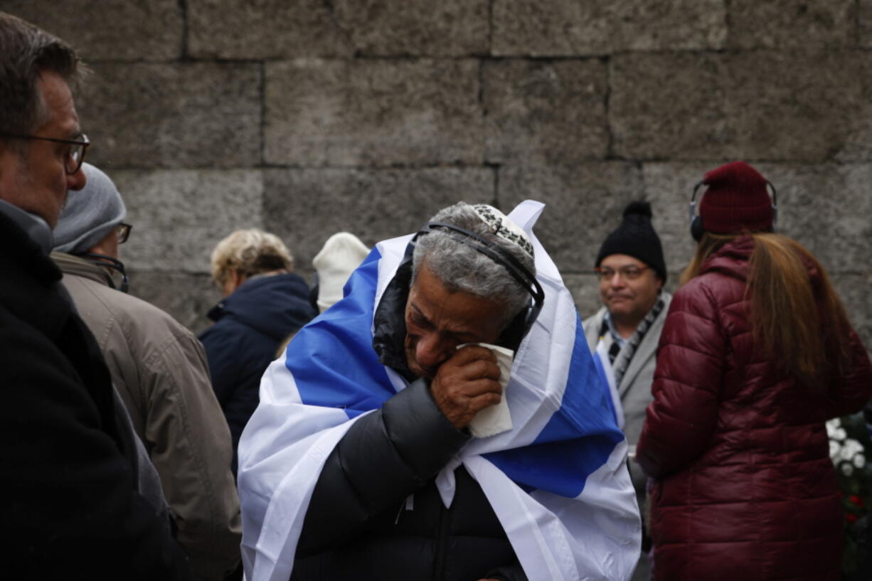 Zvika Karavany, 72, a Yemeni-born Israeli, wipes his tears in front of the Death Wall in the former Nazi German concentration and extermination camp Auschwitz during ceremonies marking the 78th anniversary of the liberation of the camp in Oswiecim, Poland, Friday, Jan. 27, 2023.